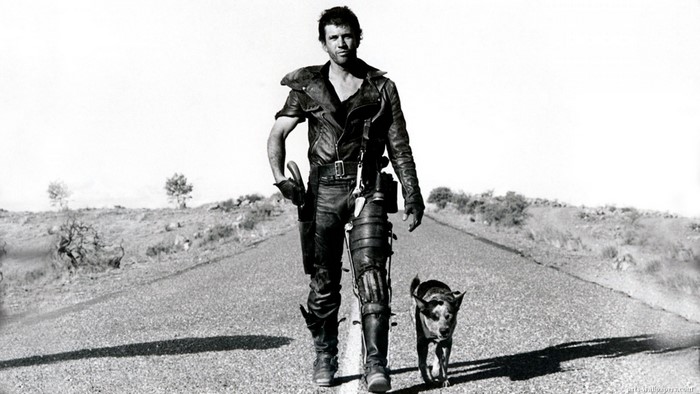 Mel Gibson as Mad Max walking with a dog