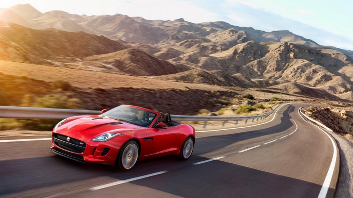 Red Jaguar F-Type Convertible driving on a mountain road