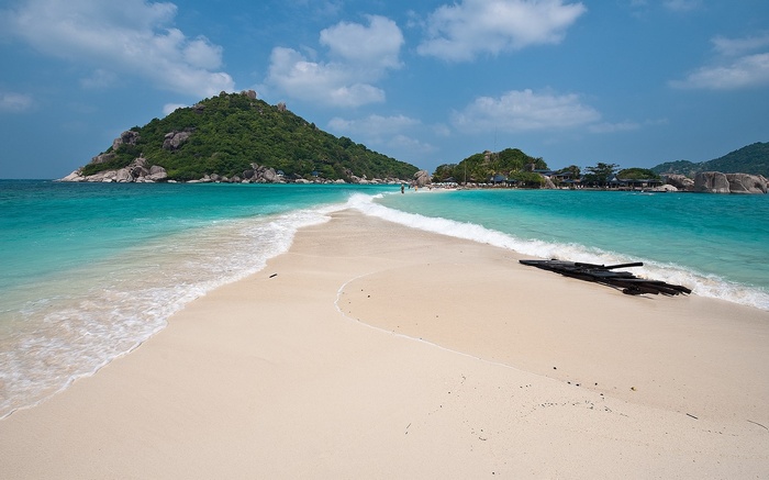 Sandy beach with turquoise water and green islands