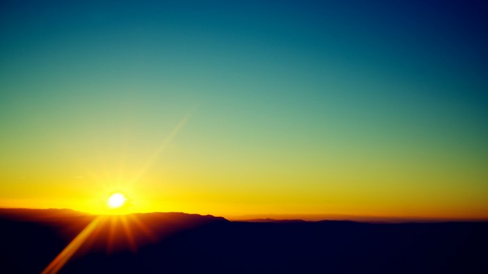 Sunrise over mountains with sun rays