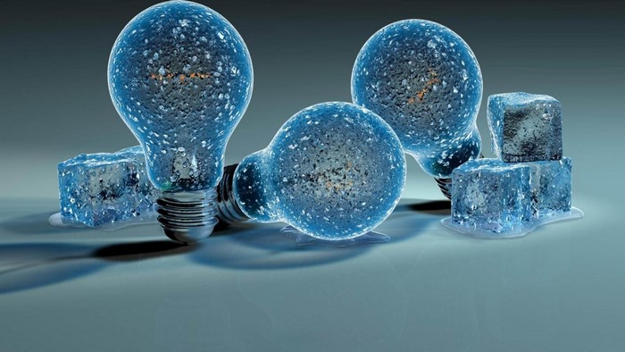 Frozen light bulbs and ice cubes on a reflective surface