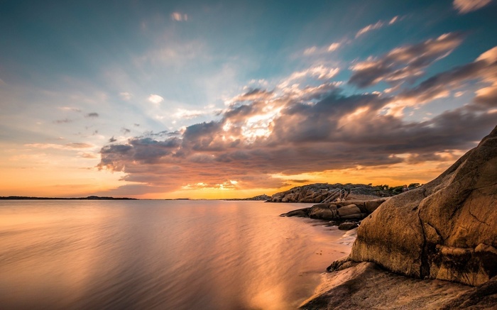 Sunset over rocky coast with calm water