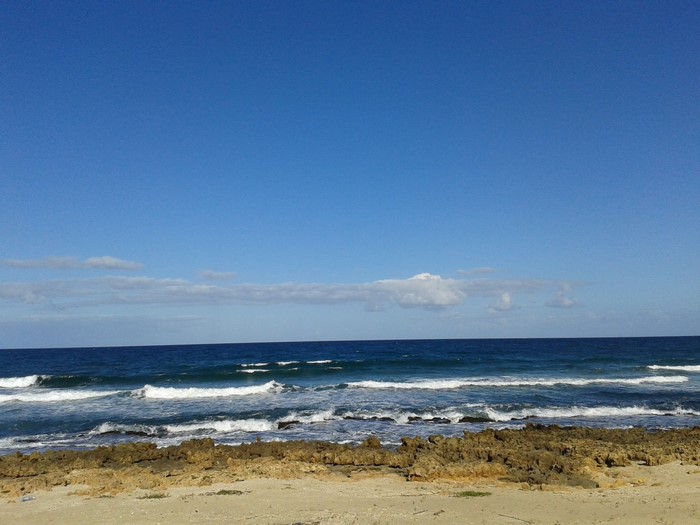 Rocky shore with waves under a blue sky