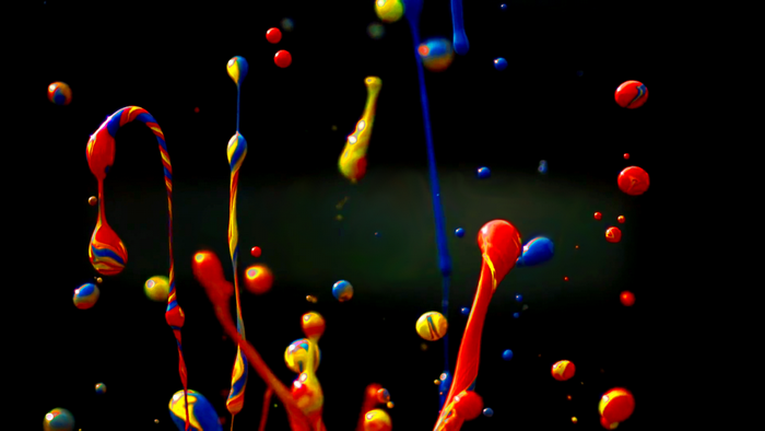 Colorful paint splatters against a black background