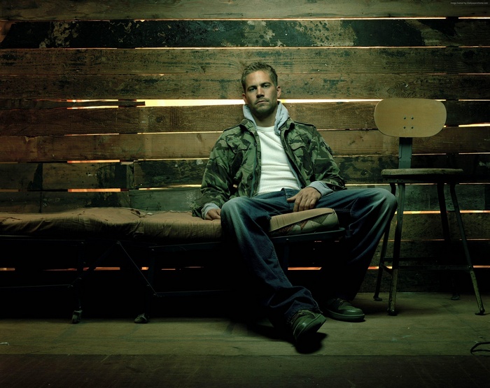 Paul Walker sitting on a cot
