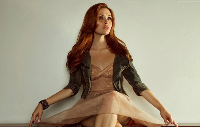 Holland Roden sitting in a dress and jacket