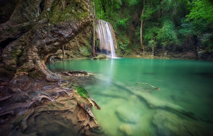Waterfall cascading into a turquoise pool in a tropical rainforest