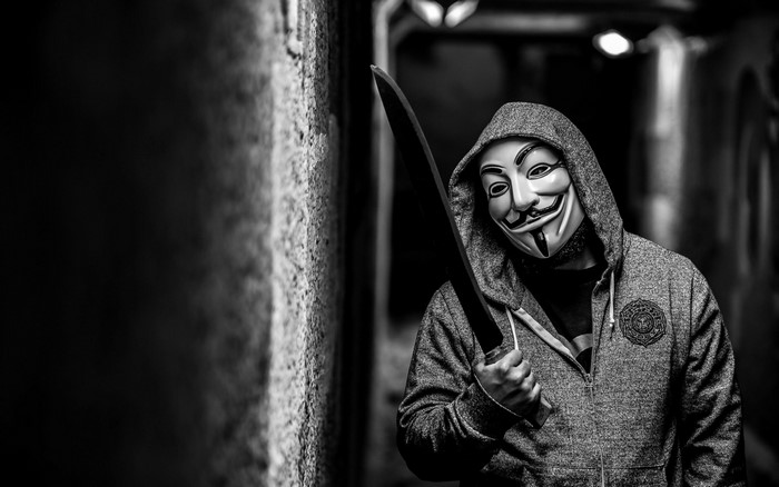 Man in Anonymous mask holding a sword