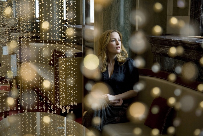 Gillian Anderson sitting on a couch