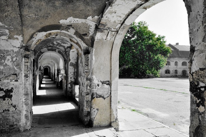 Old abandoned arcade with arches and a courtyard