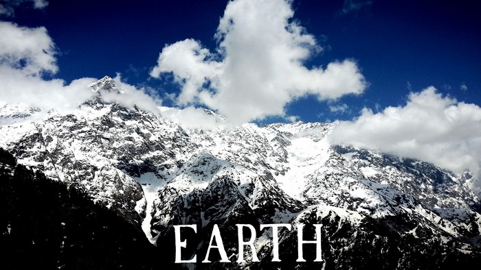 Snow-covered mountains under a blue sky with clouds