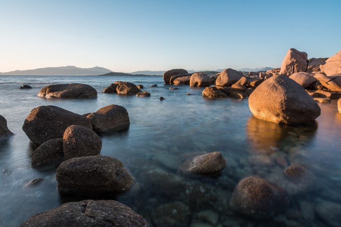 Rocky coastline at sunset with calm sea