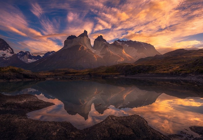 Torres del Paine mountains reflected in a lake at sunset