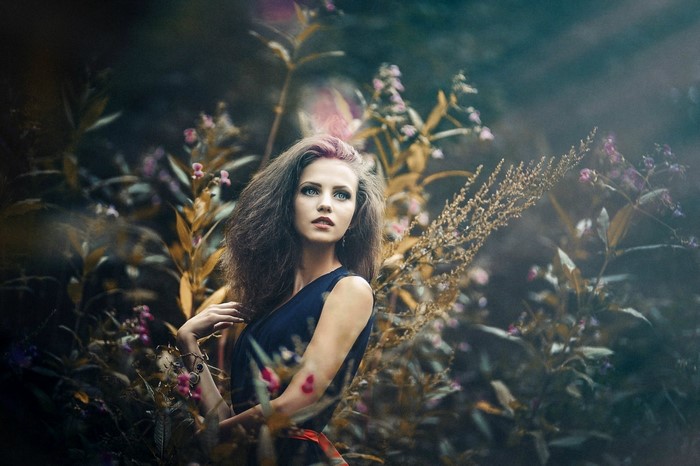 Woman with long hair and blue eyes in a garden