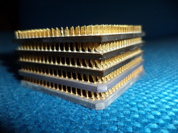 Stack of CPUs with gold pins on blue textured surface