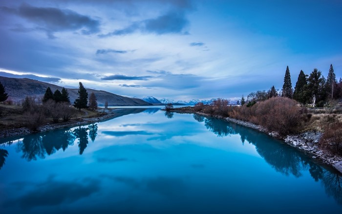 Lake reflection with mountains and trees at dusk