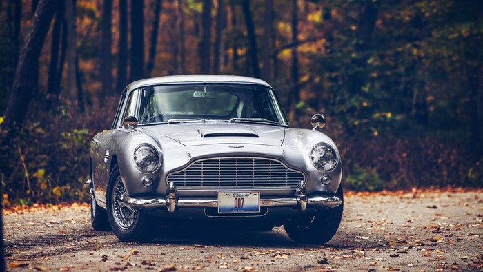 Silver Aston Martin DB5 with 007 license plate in forest