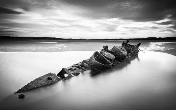 Monochrome long exposure of a shipwreck on a beach