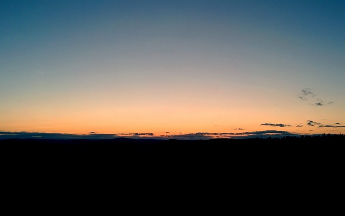 Sunset over a dark horizon with a gradient sky