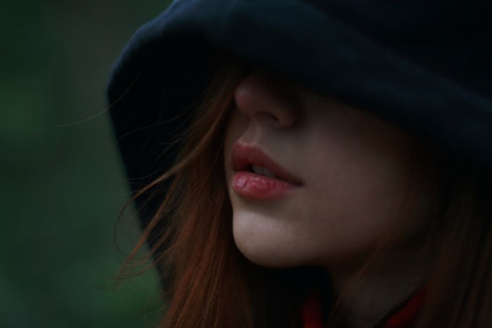 Mysterious Woman in Dark Hood with Red Hair