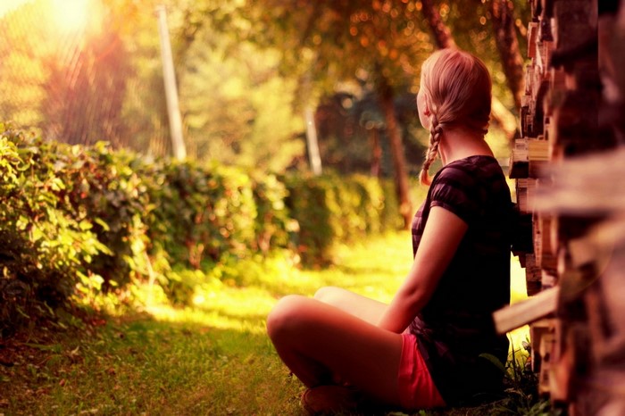 Woman sitting in a garden with sunlight