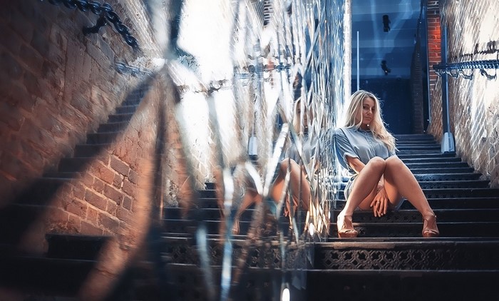 Woman sitting on stairs in a brick hallway