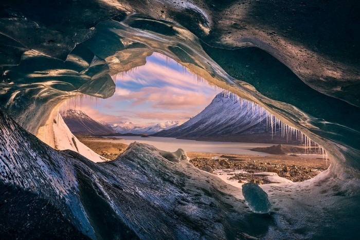 Ice cave overlooking a glacial lake and mountains