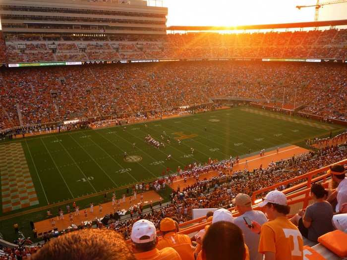American football stadium at sunset with crowds
