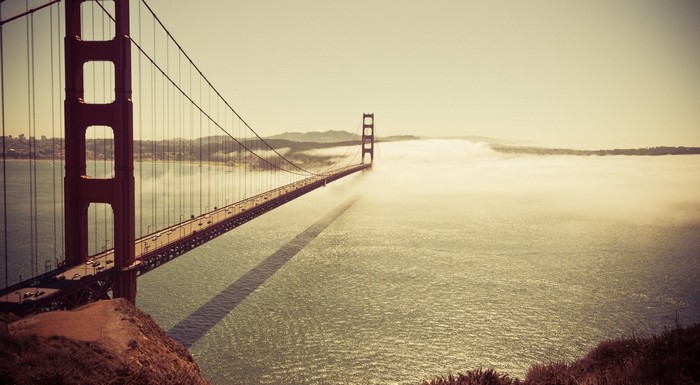 Golden Gate Bridge shrouded in fog over the ocean