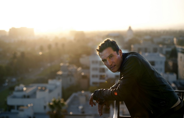 Matthew McConaughey leaning on a railing at sunset