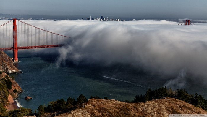 Golden Gate Bridge shrouded in fog with San Francisco skyline
