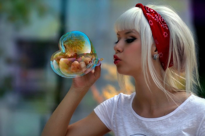 Woman blowing a heart-shaped bubble