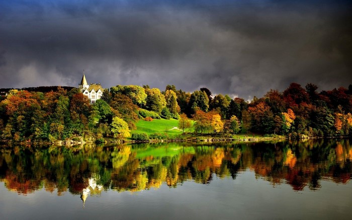 Autumn landscape with a house reflected in a lake