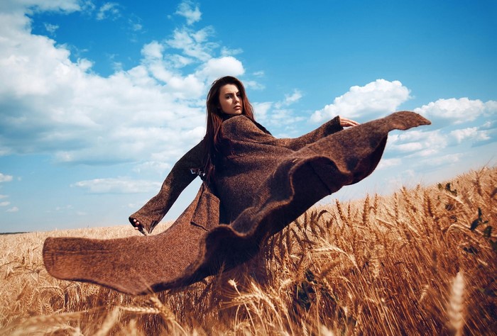 Woman in a brown coat in a wheat field