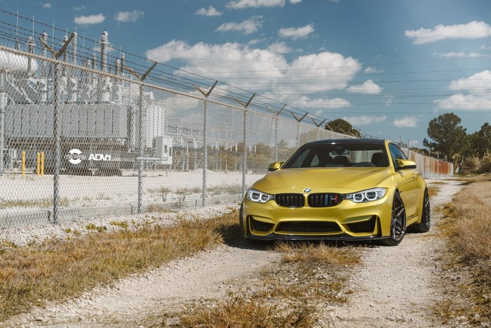 Yellow BMW M4 with ADV.1 Wheels near Power Station
