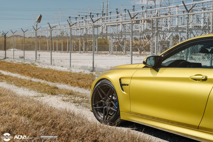 Yellow BMW M4 with ADV.1 Wheels near Power Station