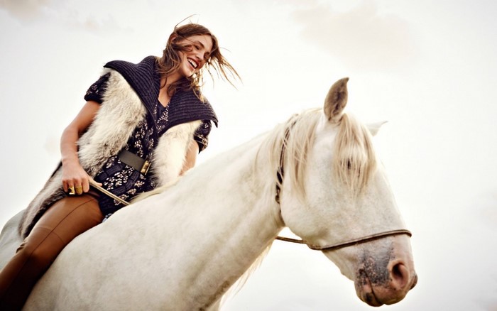 Woman riding a white horse