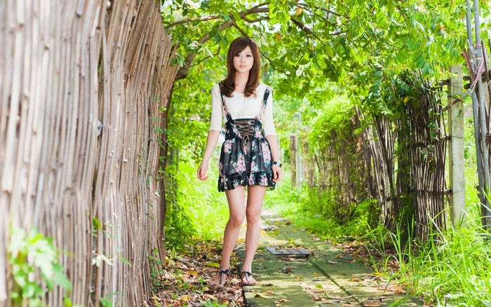 Asian woman in floral dress in a garden
