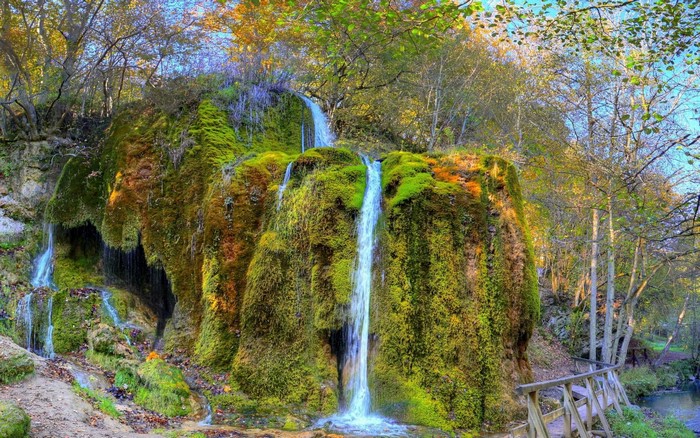 Moss-covered waterfall in an autumn forest