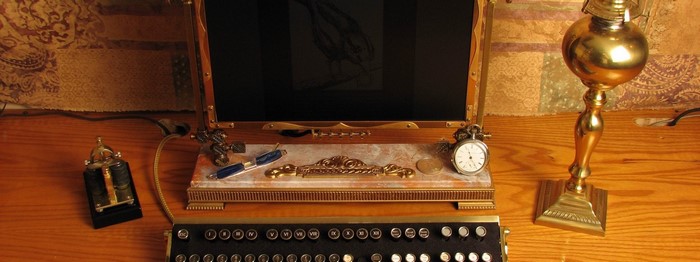 Steampunk computer with typewriter keyboard and brass lamp