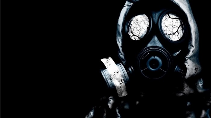 Person wearing a gas mask in darkness