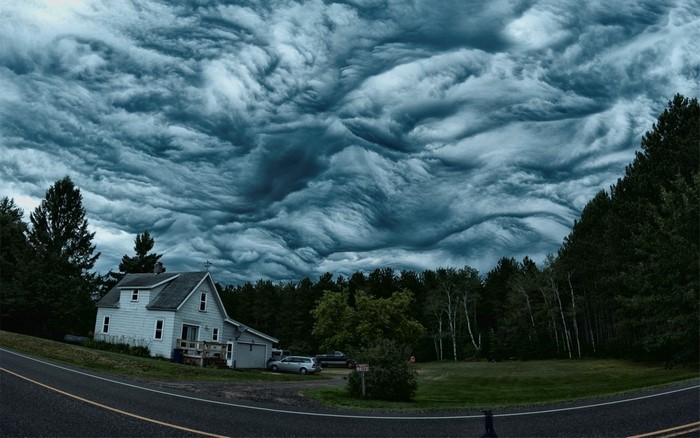 Stormy sky over a house and forest