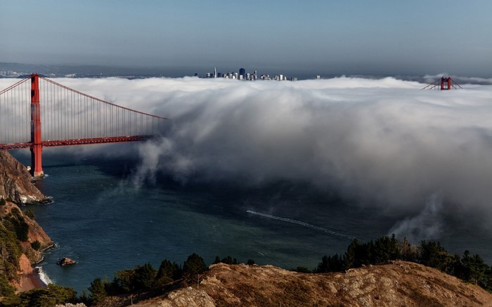 Golden Gate Bridge shrouded in fog with San Francisco skyline
