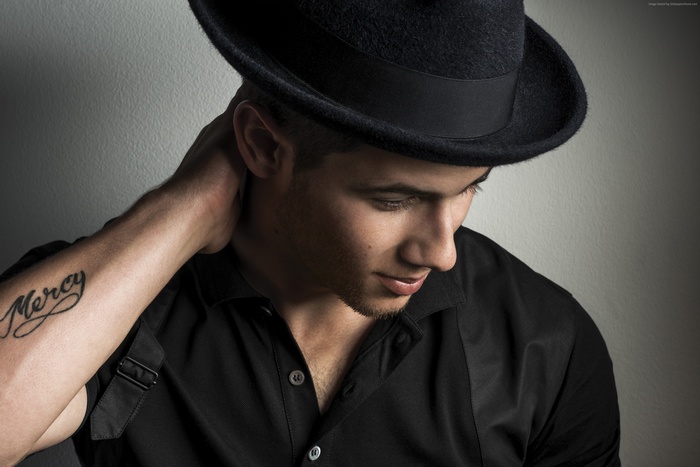 Nick Jonas wearing a black hat and shirt
