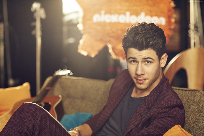 Nick Jonas on a couch with Nickelodeon logo