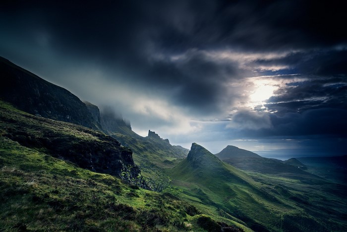 Dramatic mountain landscape with sun breaking through clouds