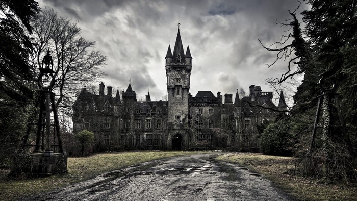 Abandoned castle with a clock tower and surrounding trees