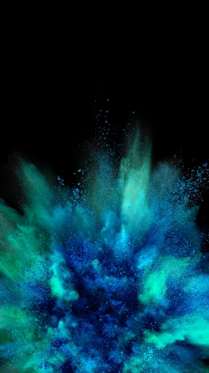 Explosion of blue and green powder in darkness