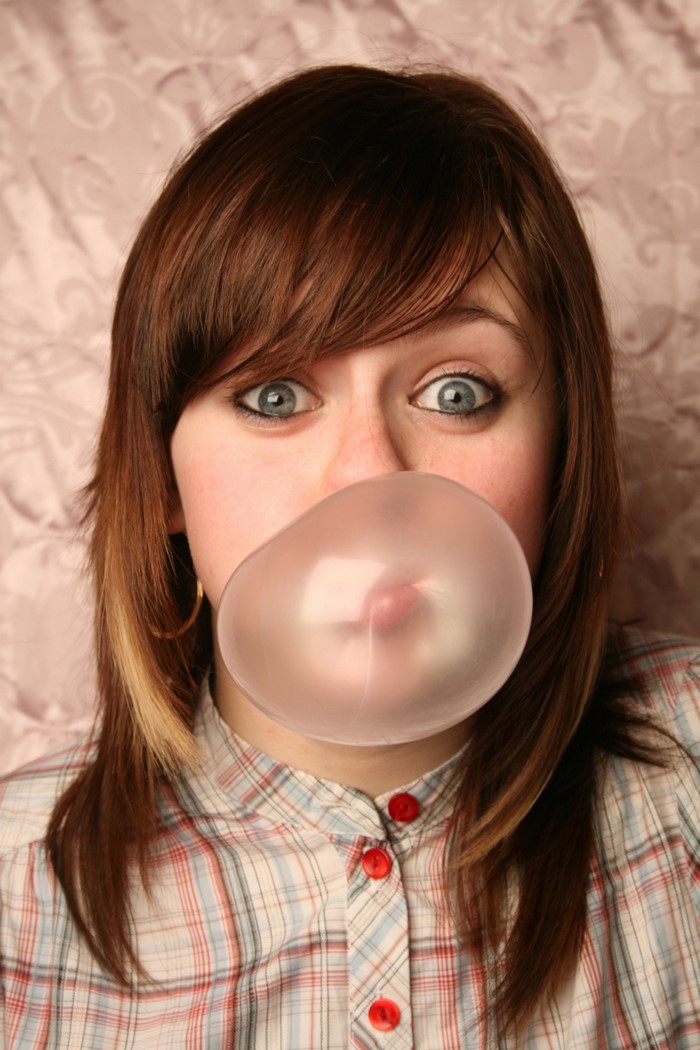 Girl blowing a large bubble gum bubble