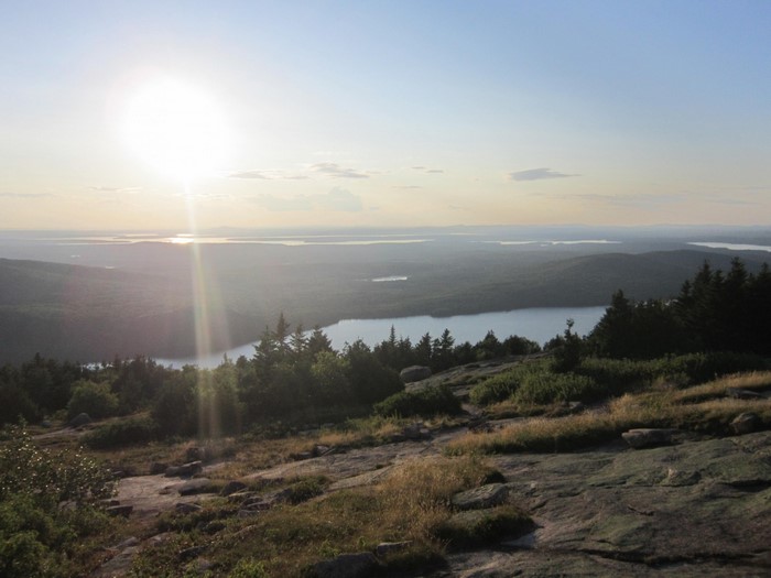 Sunlight over a lake and hills